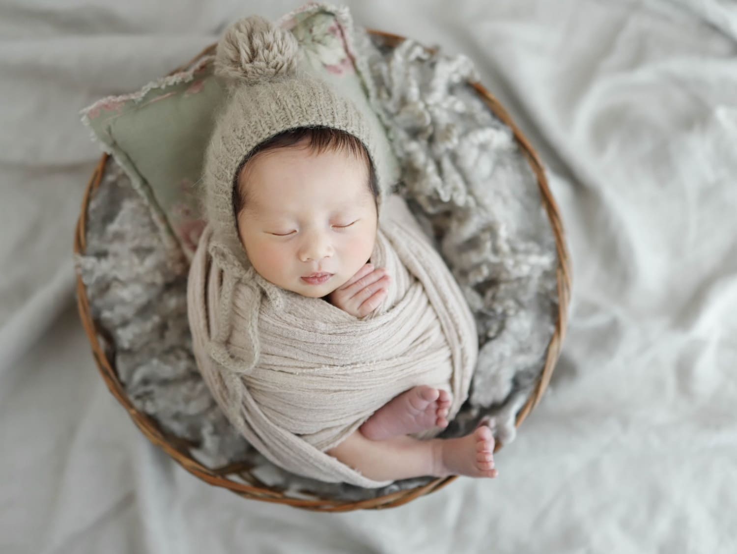 おくるみに包まれて眠る新生児のニューボーンフォト