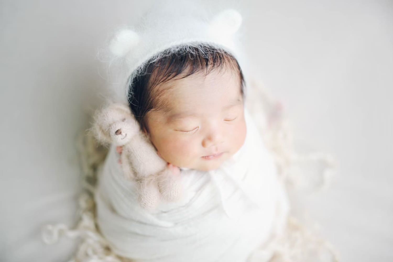 親の大きな手に包まれた新生児の小さな手のニューボーンフォト